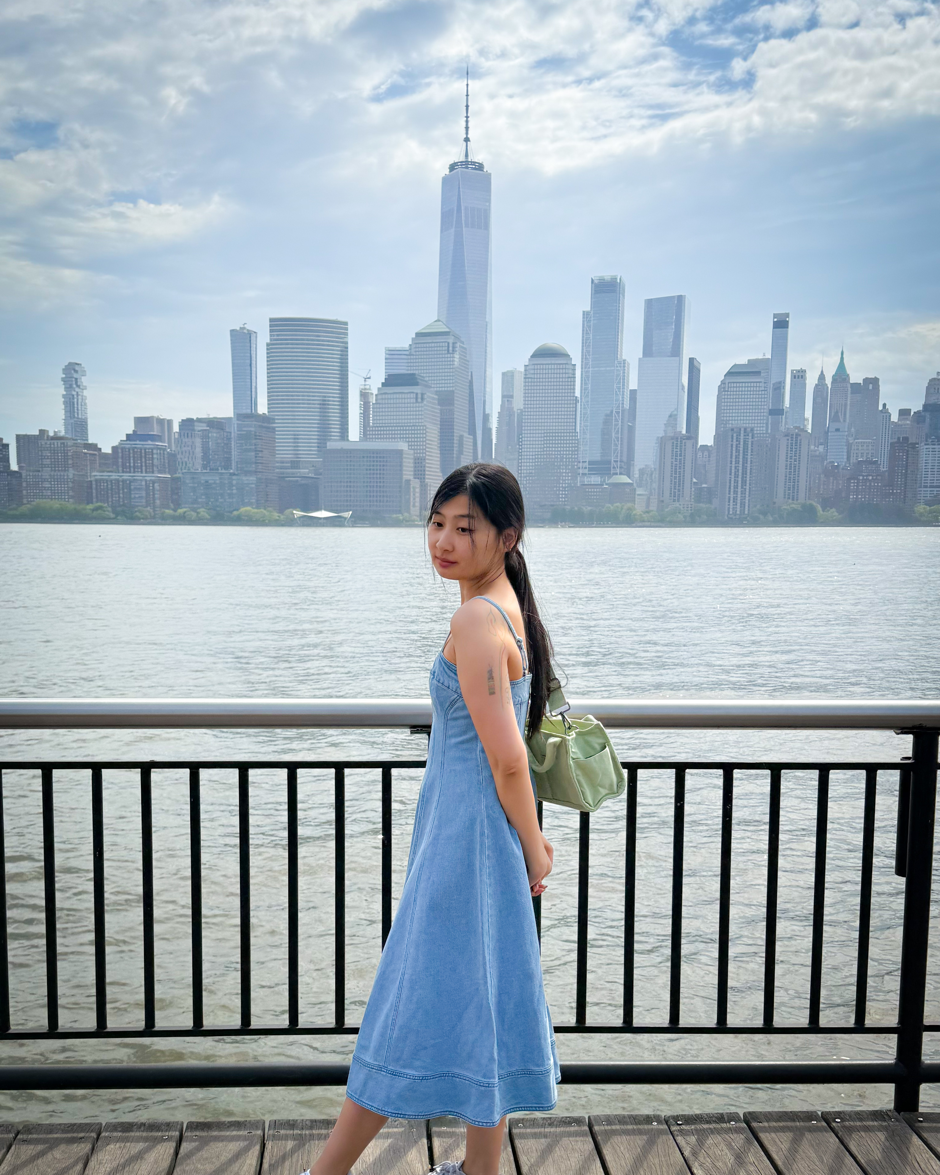 An Asian 30 year old girl posing in front of the World Trade Center